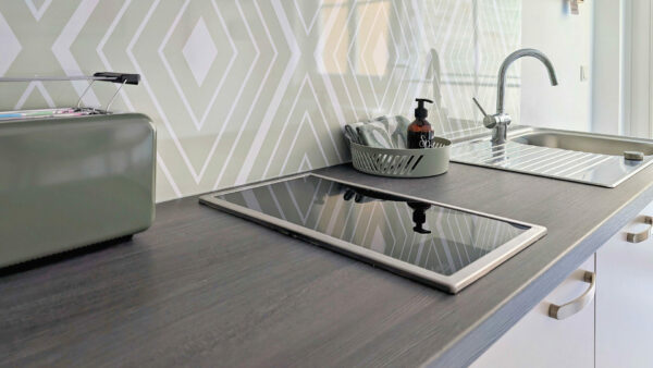 MainZauber Apartments früher MainTerrasse Miltenberg am Main - Exklusive Küchenzeile mit Induktionskochfeld, Spüle, Abtropfgestell, Brotkasten und Fliesenspiegel - ideal für Ihre Ferienwohnung.