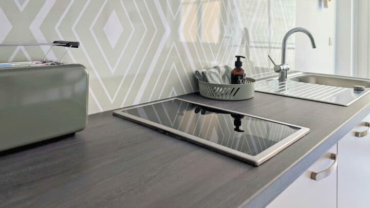 MainZauber Apartments früher MainTerrasse Miltenberg am Main - Exklusive Küchenzeile mit Induktionskochfeld, Spüle, Abtropfgestell, Brotkasten und Fliesenspiegel - ideal für Ihre Ferienwohnung.