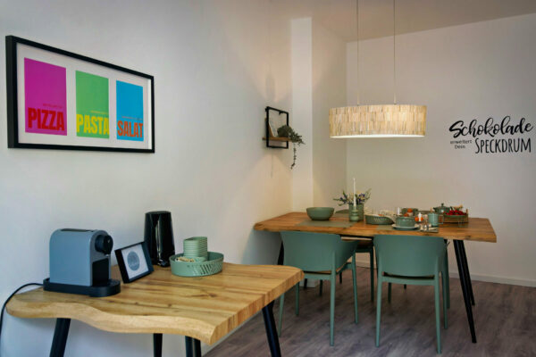 MainZauber Apartments früher MainTerrasse Miltenberg am Main - Luxuriöse Ferienwohnung in Miltenberg: Moderner Essbereich mit Holztischen, Kaffeemaschine & stilvoller Ausstattung.