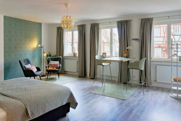 MainZauber Apartments früher MainTerrasse Miltenberg am Main - Luxuriöses, helles Feriendomizil in der Altstadt: großes Fenster, Bett, Lounge, Esstisch, edle Ausstattung - Ihr Urlaubsapartment.