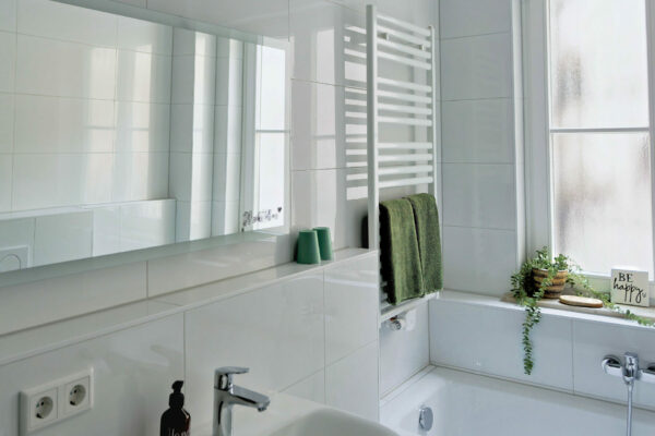 MainZauber Apartments früher MainTerrasse Miltenberg am Main - Modernes Bad der Luxusferienwohnung AltstadtZauber Miltenberg: Wanne, Pflanzen, Spiegel, Komfortausstattung und Deko.