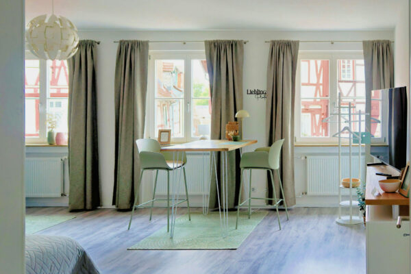 MainZauber Apartments früher MainTerrasse Miltenberg am Main - Luxuriöses Apartment für den Urlaub: Helles Wohnambiente, großes Fenster, Holztisch, minimalistisch, zentrale Unterkunft Miltenberg.