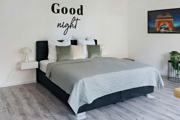 MainZauber Apartments früher MainTerrasse Miltenberg am Main - Modernes Schlafzimmer in luxuriöser Ferienwohnung: Bequemes Bett, grün-weiße Kissen, stilvolle Deko, Top-Unterkunft Altstadt.