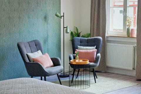 MainZauber Apartments früher MainTerrasse Miltenberg am Main - Stilvolle Luxus-Ferienwohnung: Zwei graue Sessel, elegante Deko, viel Licht - Ihre exklusive Unterkunft in der Altstadt Miltenbergs.