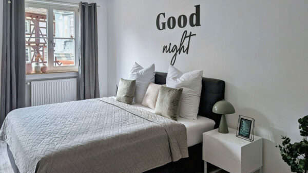 MainZauber Apartments früher MainTerrasse Miltenberg am Main - Modernes Schlafzimmer mit komfortablem Doppelbett und stilvollen Details in der luxuriösen Ferienwohnung AltstadtZauber Miltenberg.