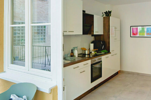 MainZauber Apartments früher MainTerrasse Miltenberg am Main - Moderne Küche mit weißen Schränken, Backofen, Geräten und viel Licht - perfekte Ausstattung für Ihre Luxus-Ferienwohnung in der Altstadt.