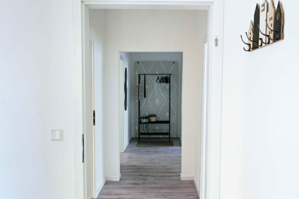 MainZauber Apartments früher MainTerrasse Miltenberg am Main - Heller Flur mit weißen Wänden und Parkett im Luxus-Apartment AltstadtZauber Miltenberg, moderner Eingangsbereich, stilvoll möbliert.