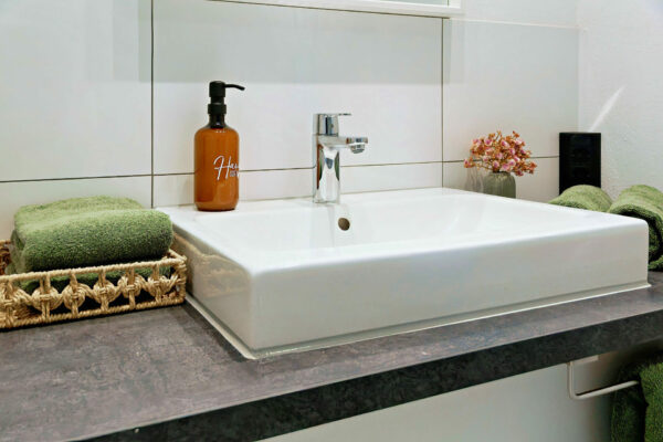 MainZauber Apartments früher MainTerrasse Miltenberg am Main - Stilvolles Bad mit modernem Waschbecken, Luxusarmatur, Deko und Handtüchern - ideal für Ihre Luxusferienwohnung.