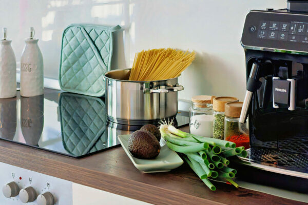 MainZauber Apartments früher MainTerrasse Miltenberg am Main - Moderner Küchenbereich in der luxuriösen Ferienwohnung Altstadt: Pastatopf, Avocado, Gewürze, Kaffeemaschine & Zubehör.