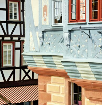 MainZauber Apartments früher MainTerrasse Miltenberg am Main - Detailaufnahme einer luxuriösen Ferienwohnung in einem bunten Fachwerkhaus, traditionelle Unterkunft mit Blick auf weitere Altbauten.